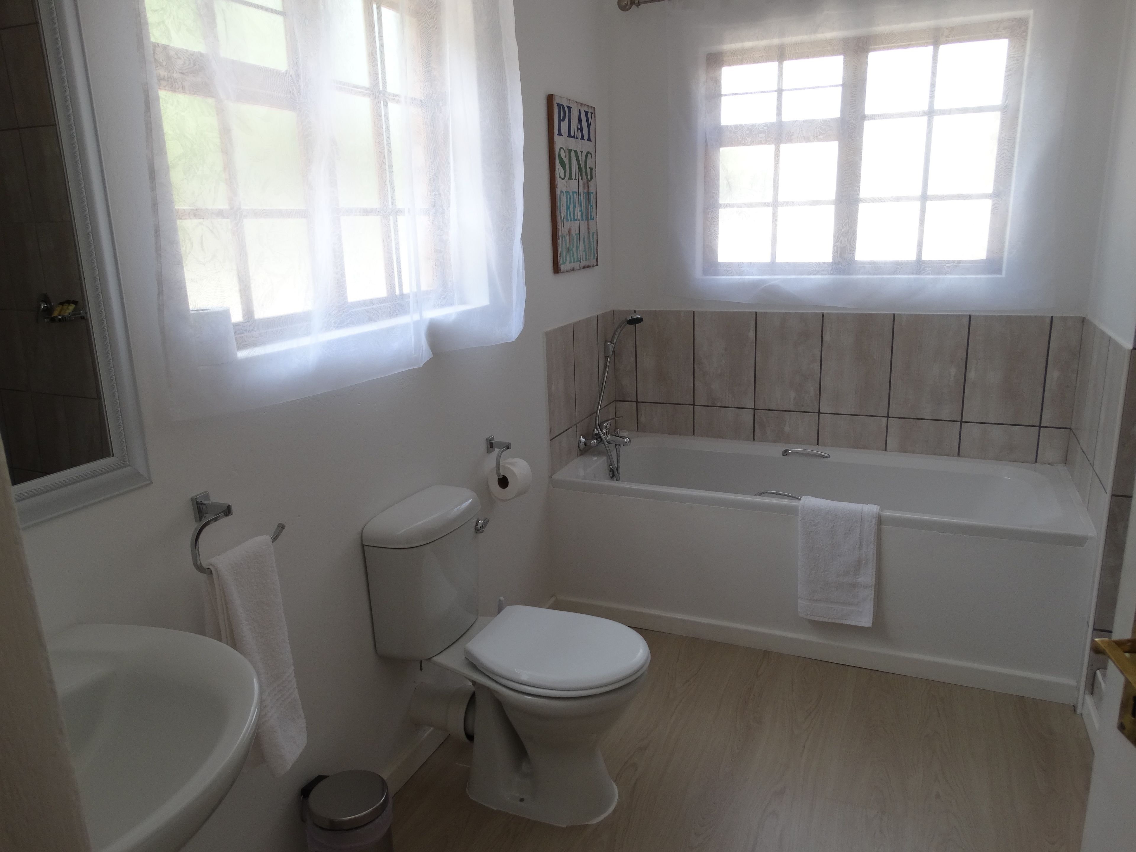 A bathroom with a toilet, sink, and bathtub.