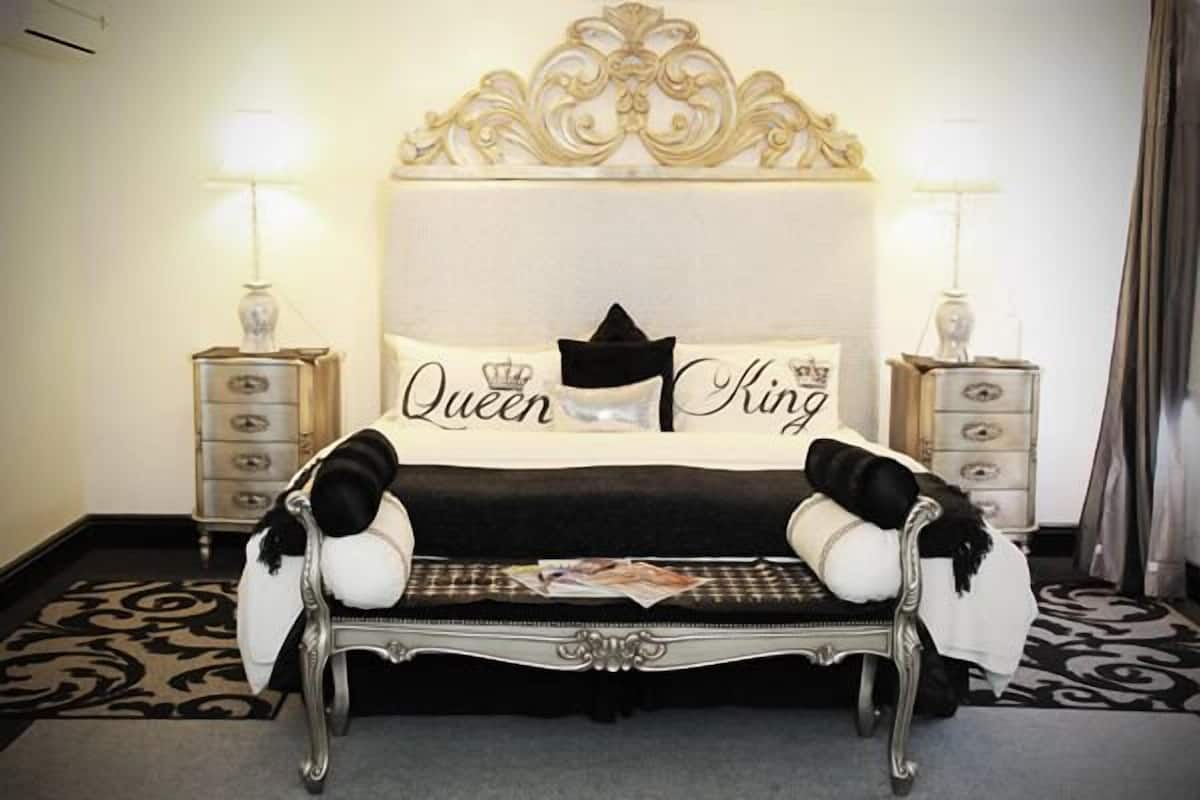 A bed with a headboard that reads "Queen King" and a decorative pillow.