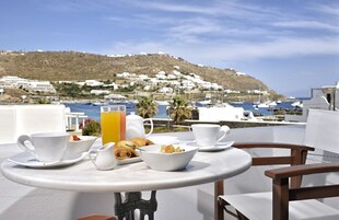 Una mesa con alimentos para el desayuno y vistas a un pueblo costero.
