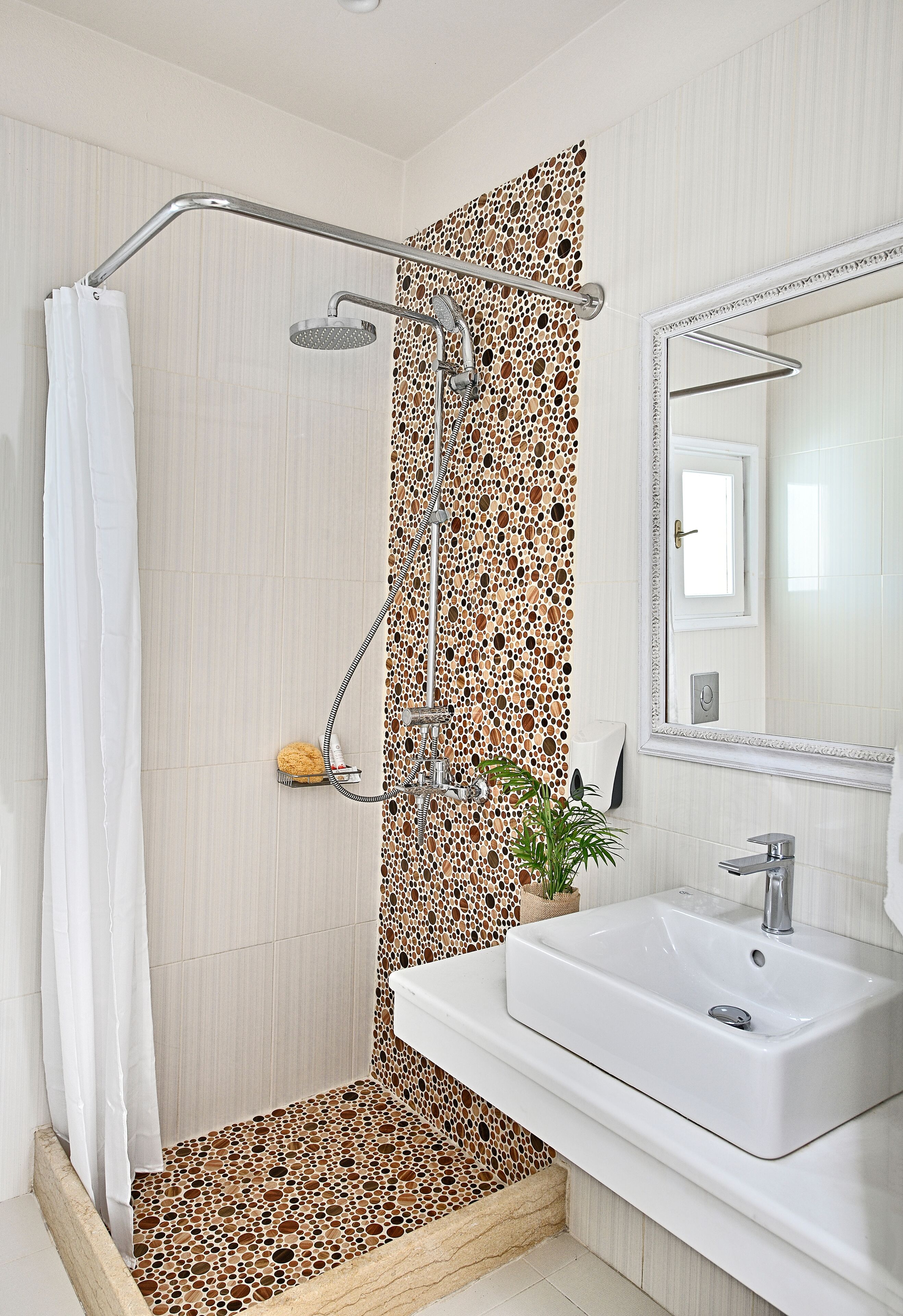 A bathroom with a shower, a sink, and a mirror.
