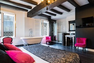 Une salle de bain moderne avec une baignoire sur pieds, un meuble-lavabo avec un miroir et un espace douche.
