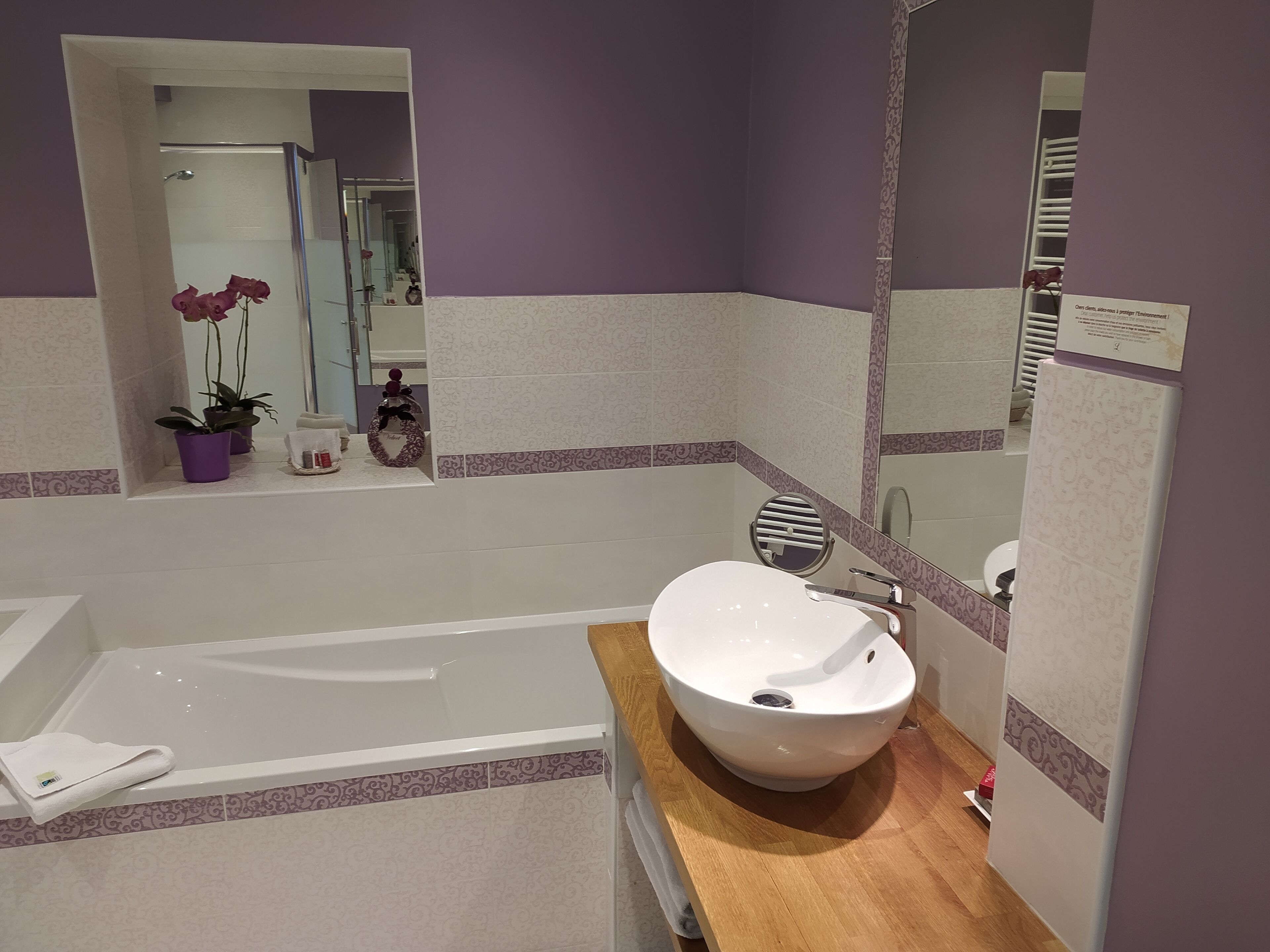 Une salle de bain moderne avec une baignoire, un lavabo et un miroir.
