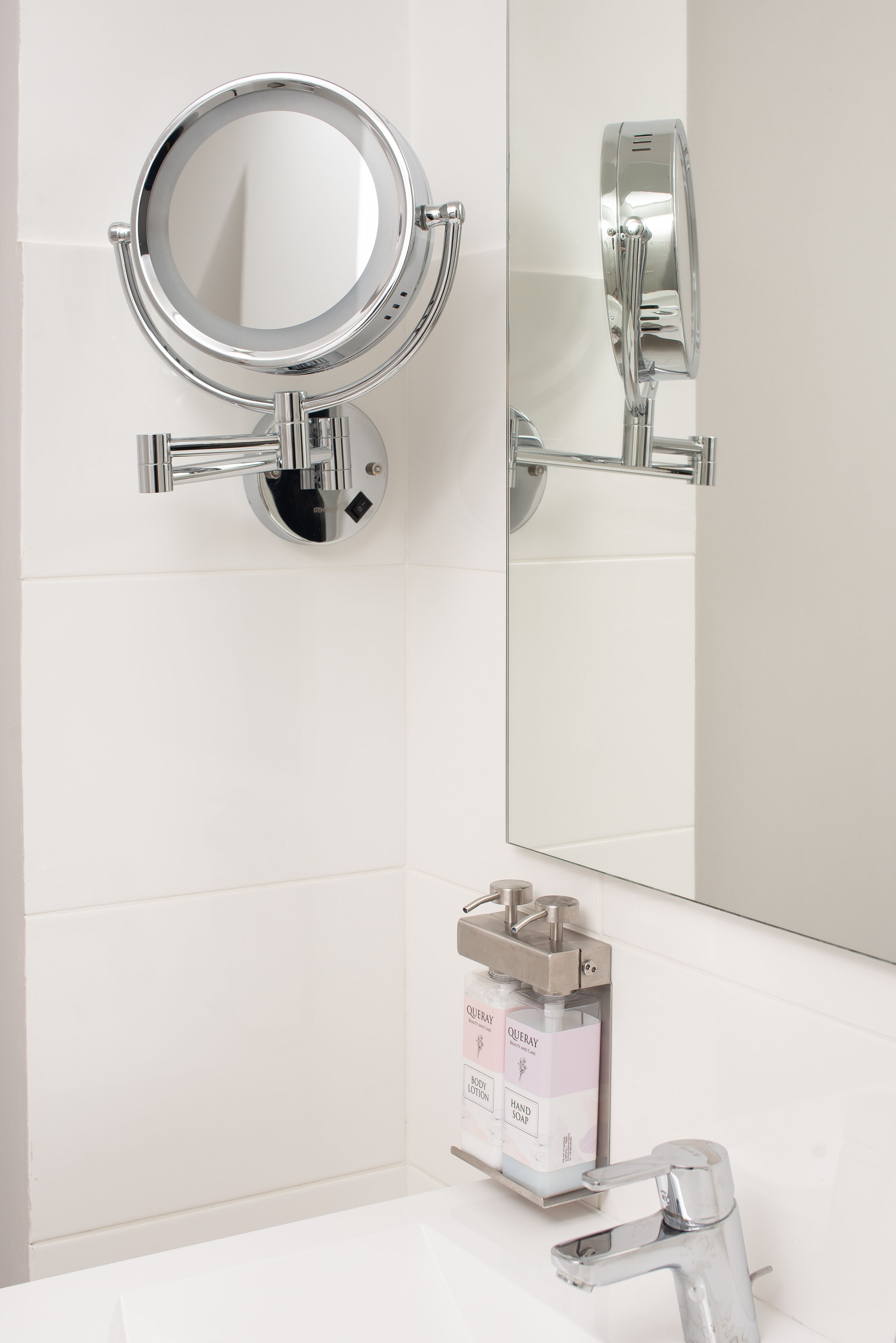 A bathroom with a wall-mounted toilet, a sink with a chrome faucet, and a mirror.