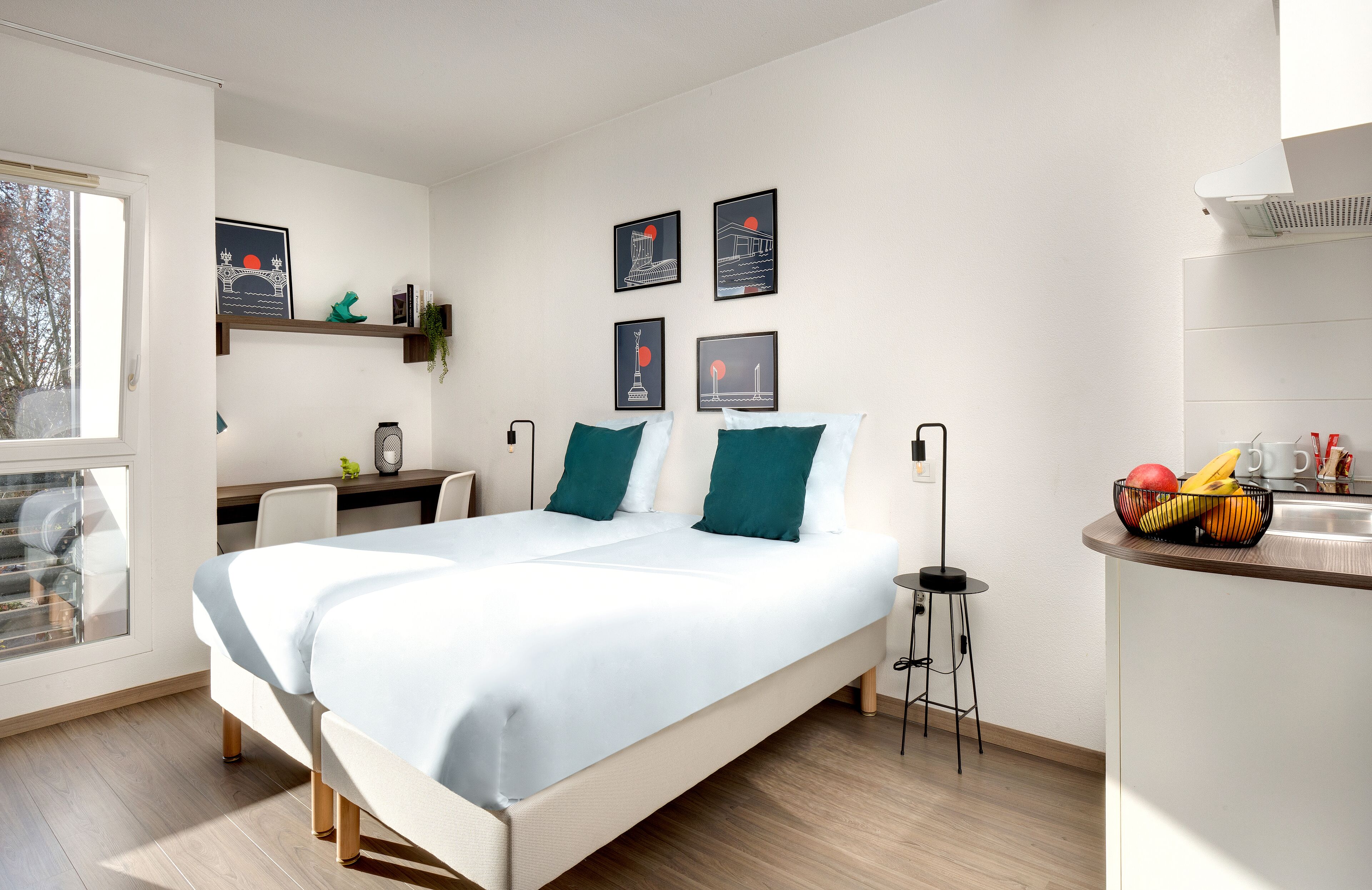 Un dormitorio moderno con una cama grande, un escritorio y una pequeña cocina.