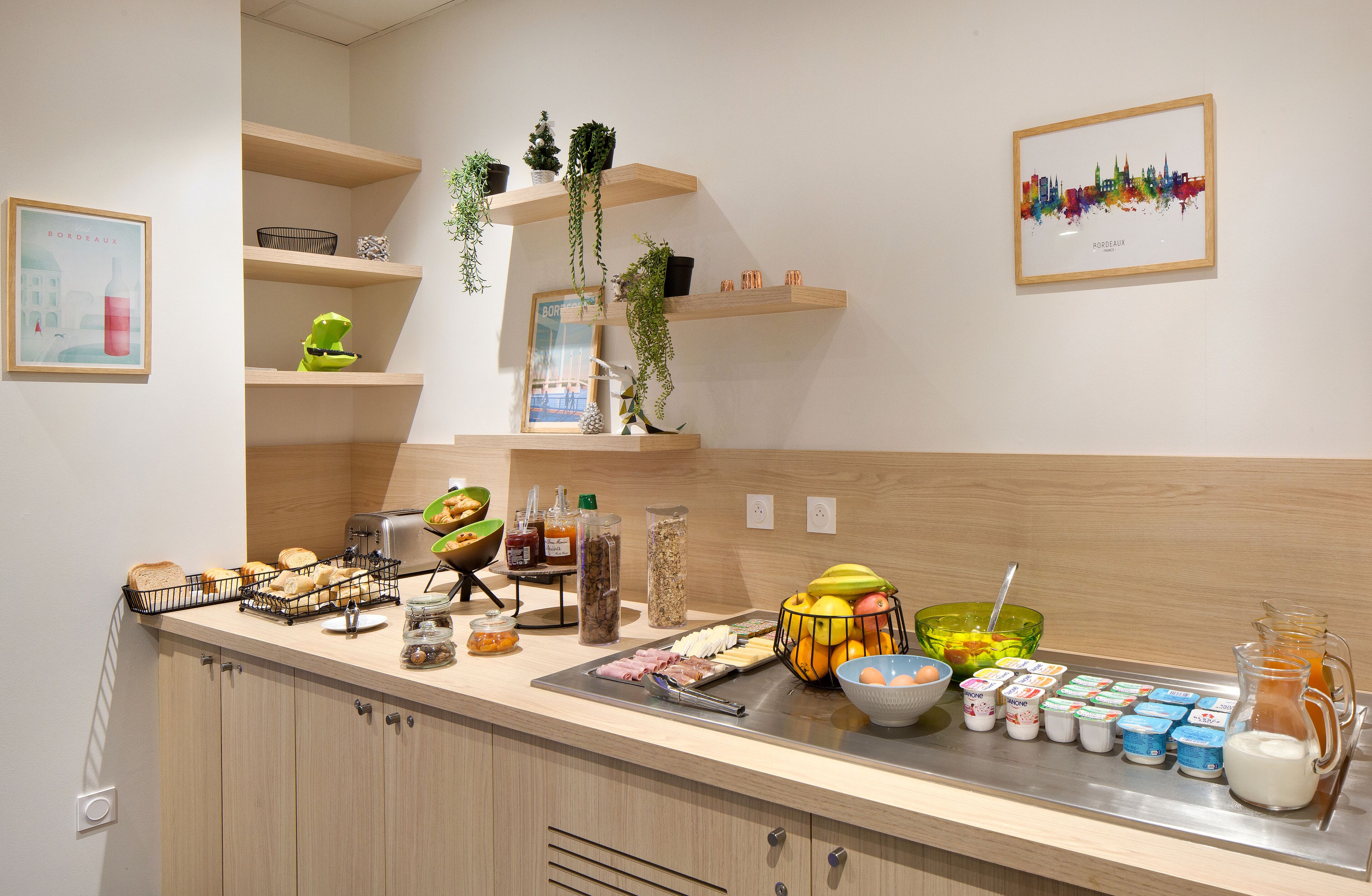 Una cocina con armarios de madera, una barra desayunadora y diversos alimentos para el desayuno.