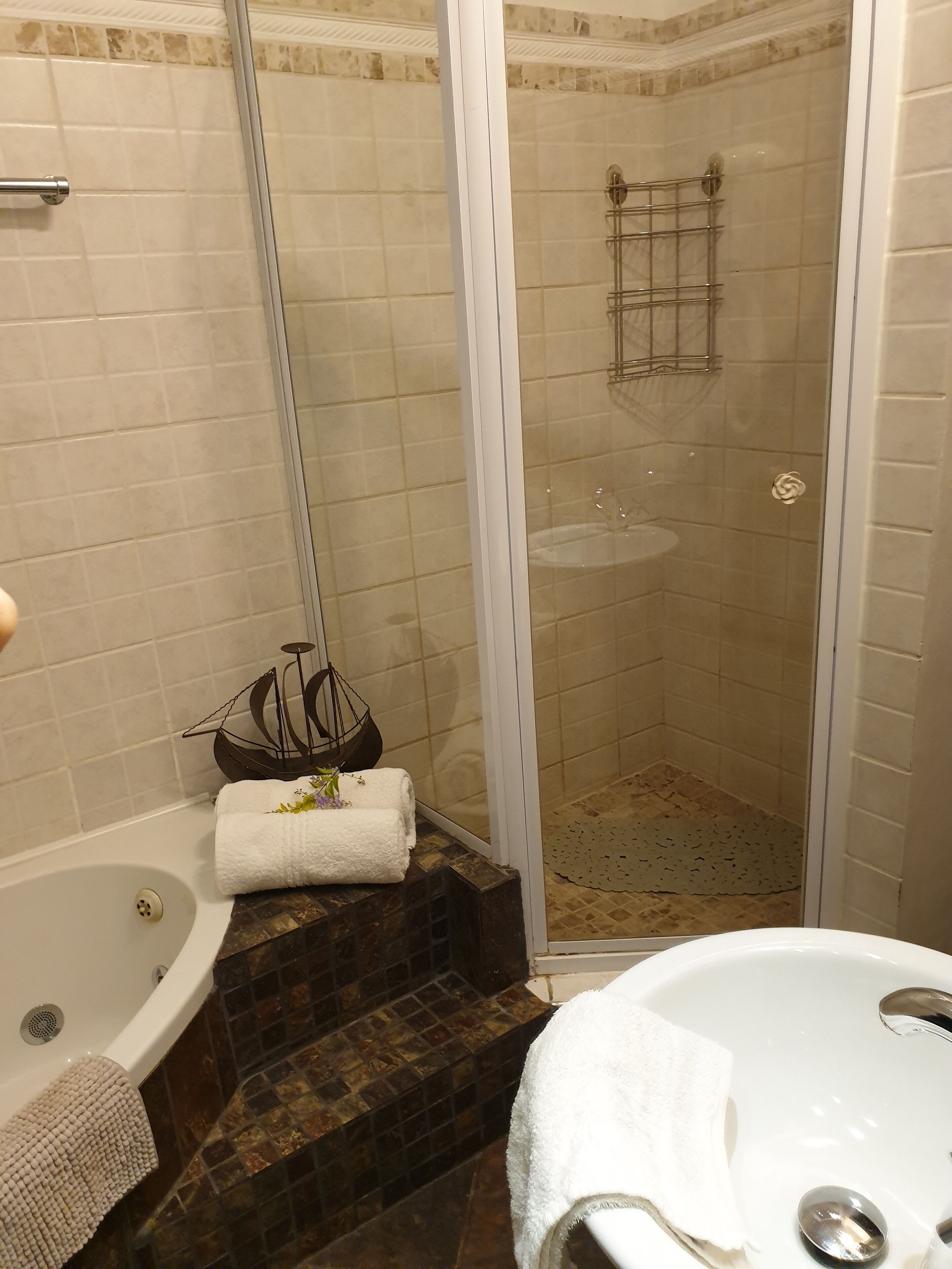 Ein Badezimmer mit Badewanne, Duschkabine und Waschbecken.