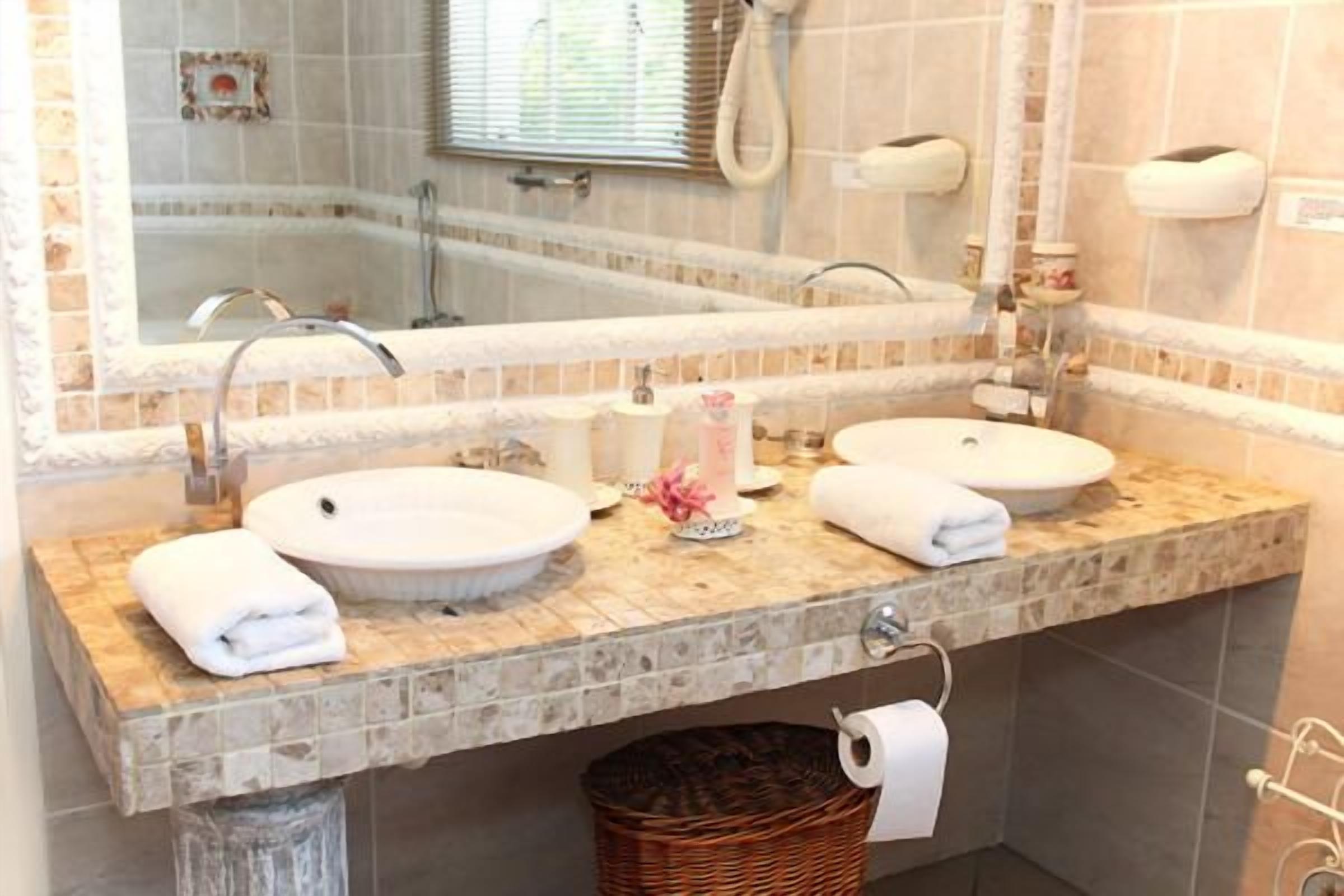 Uma casa de banho com duas pias, um espelho grande e uma banheira.