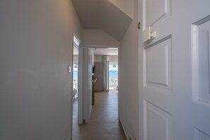 A hallway leading to a room with a view of the sea.