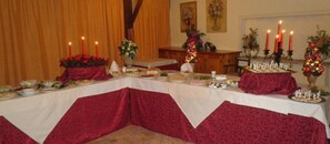 A dining table set with various dishes, candles, and floral decorations. - Hotel Il Corsaro (Isola di Capo Rizzuto)