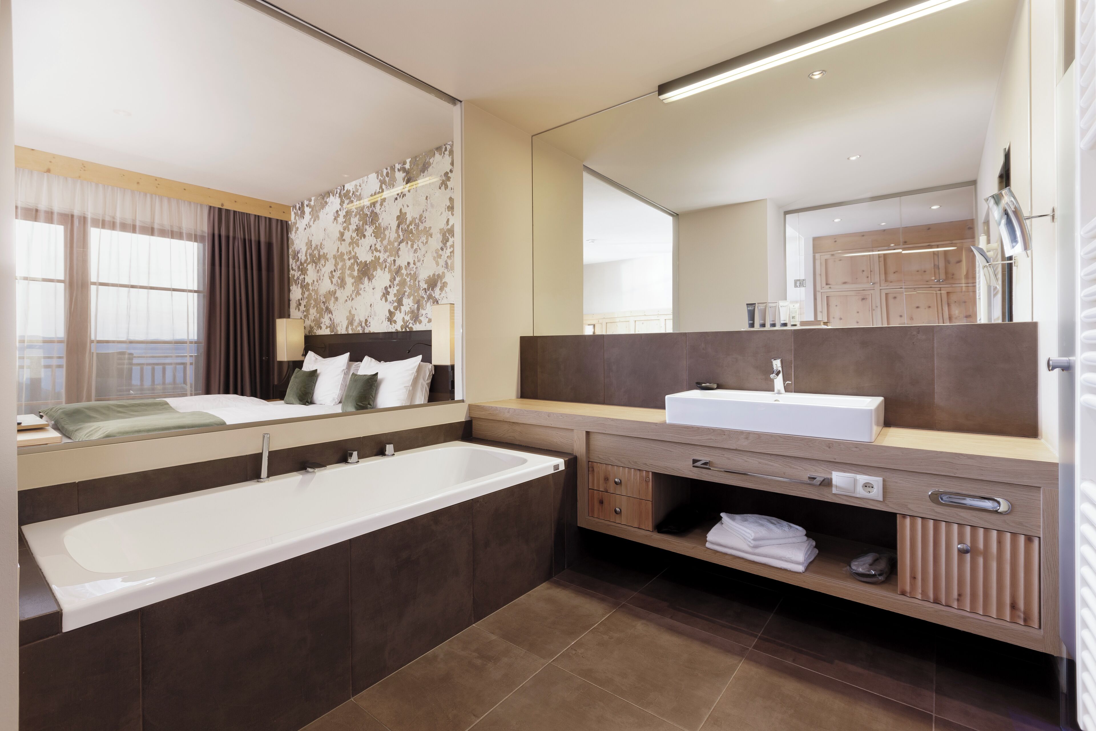 Un bagno moderno con una vasca da bagno ampia, un mobile lavabo doppio e un grande specchio.