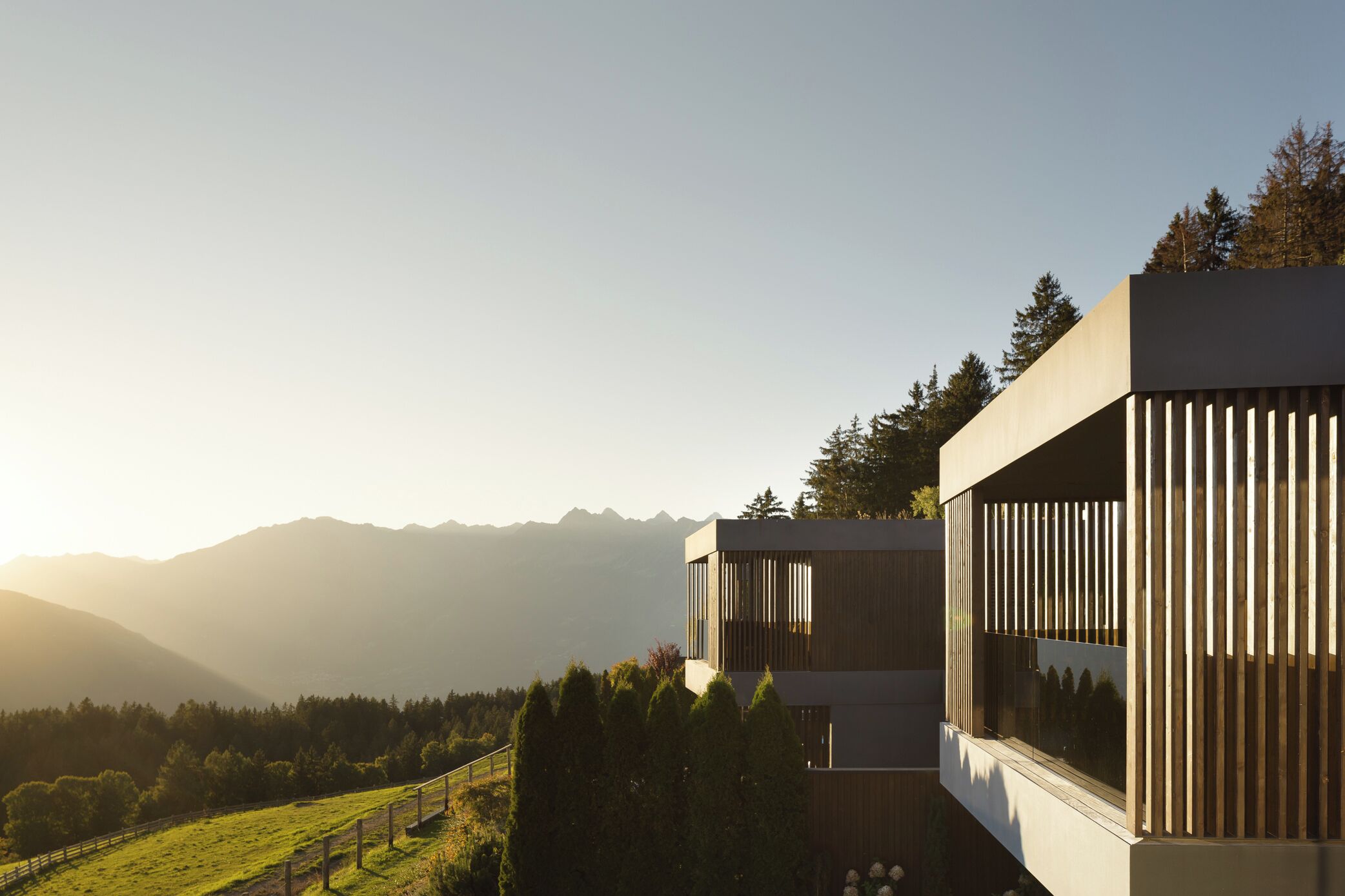 A modern building with large windows and a view of a mountainous landscape.
