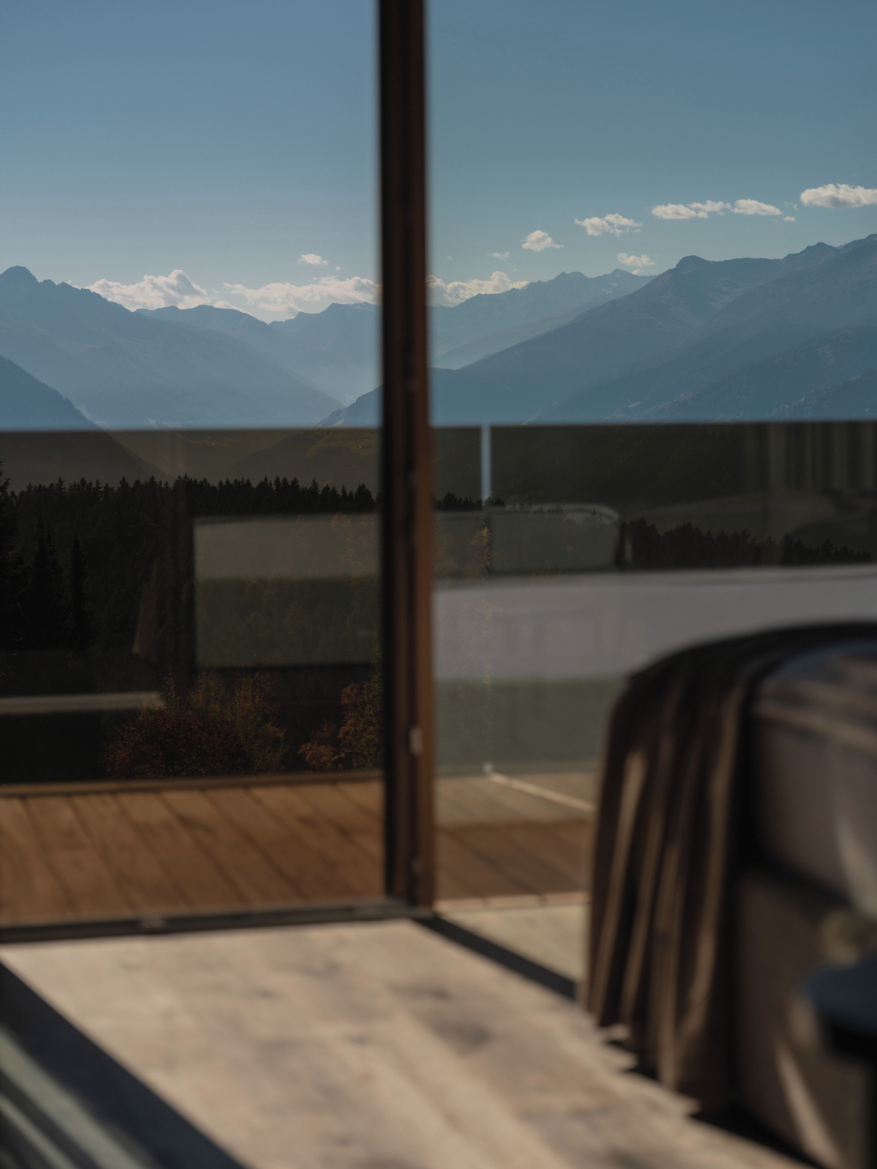 A room with a view of mountains through a window.