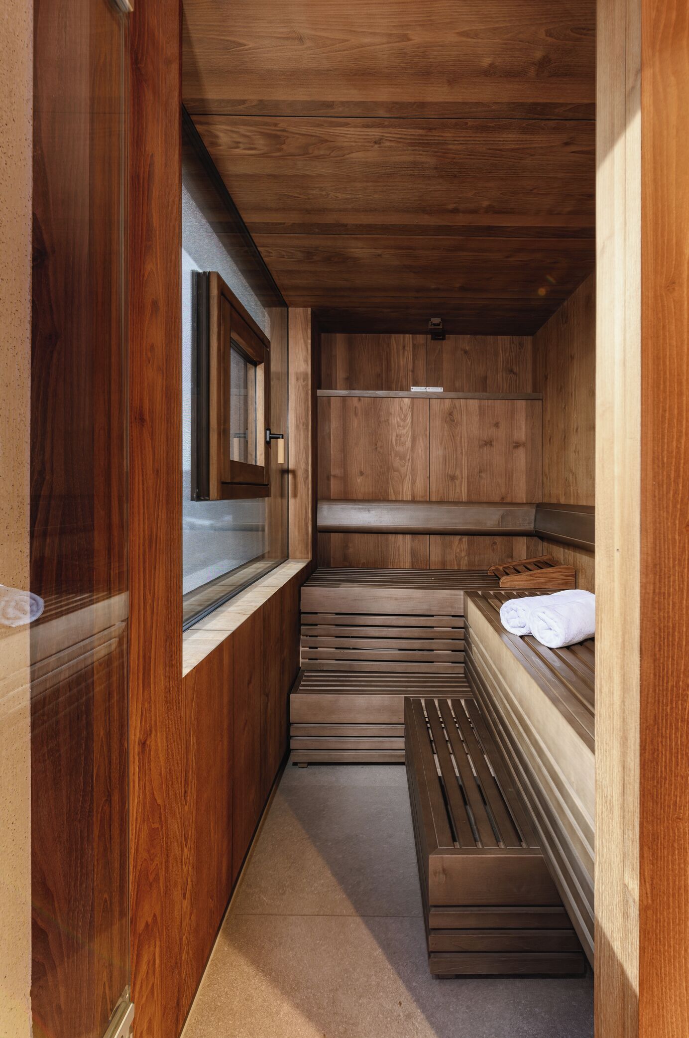 A sauna with wooden benches and a window.