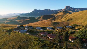 A residential area with houses on rolling hills, surrounded by mountains. - Witsieshoek Mountain Lodge (Maluti a Phofung)