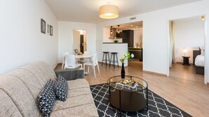 Een moderne woonkamer met een bank, een salontafel en een eetgedeelte met stoelen en een tafel.