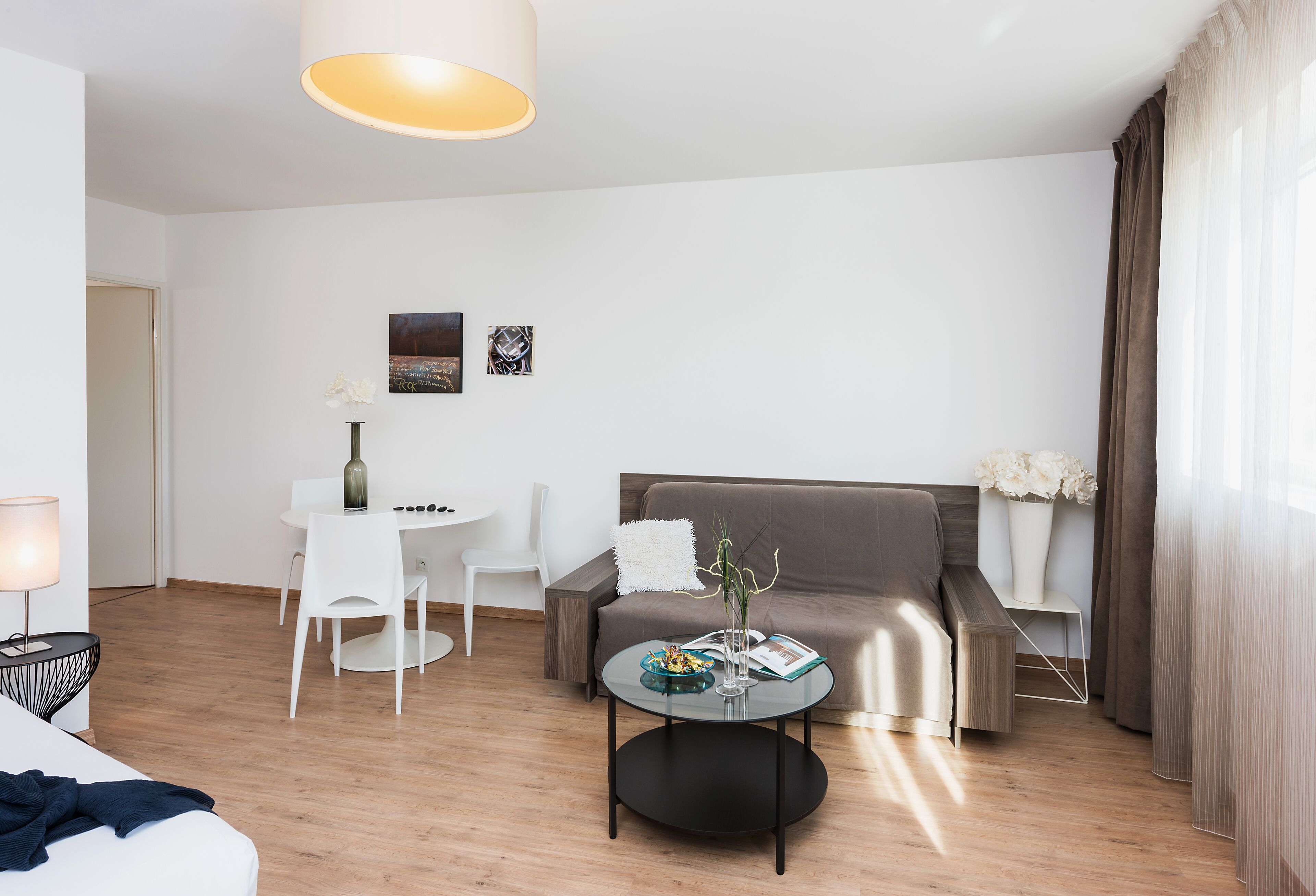 Een moderne woonkamer met een bank, een eettafel en een salontafel.