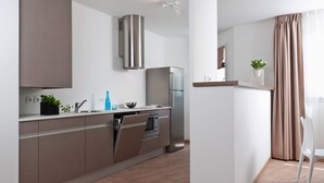 Een moderne keuken met roestvrijstalen apparatuur, houten kasten en een inbouwoven.