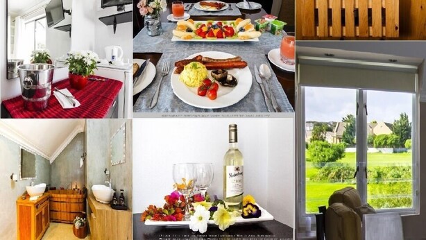 Une chambre d’hôtel avec une cheminée, un coin repas avec une table mise pour le petit-déjeuner, une clôture en bois, une salle de bain avec une baignoire et une vue sur la campagne.