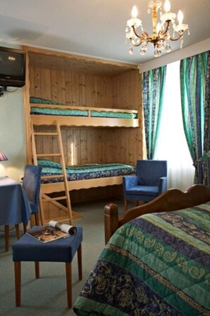 A room with bunk beds, a desk, a chair, and a chandelier. - Hotel Restaurant Robichon (Loray)