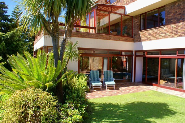 A two-story house with a patio, two chairs, and a lawn. - Magic Camps Bay (Cape Town)