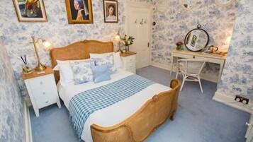 A bedroom with a bed, bedside tables, a desk, and a chair.