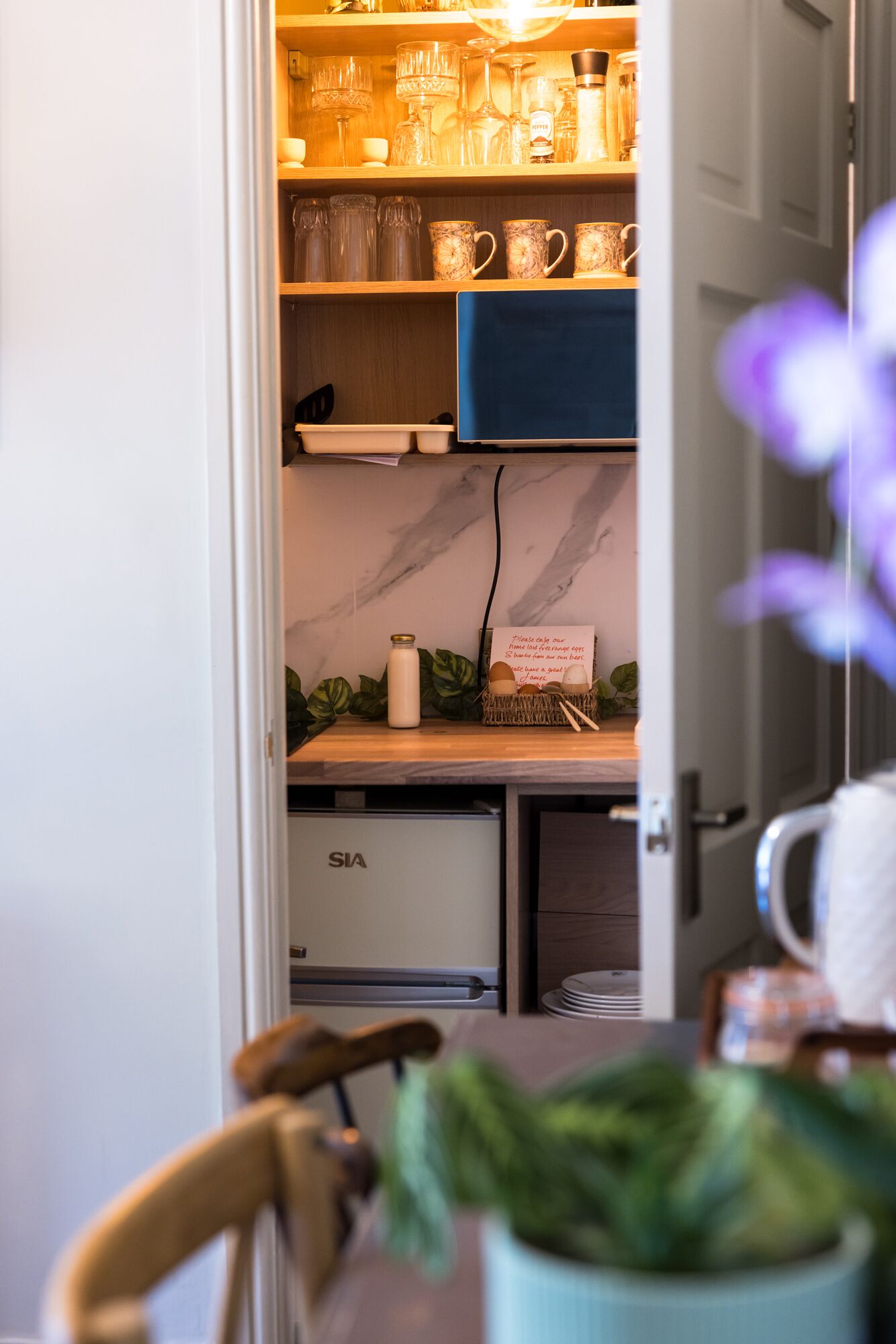 A kitchen with a marble countertop, a coffee machine, and a basket of eggs.