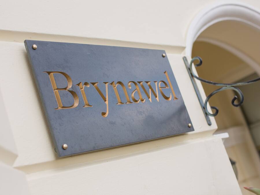 Placa com o nome 'Brynawel' fixada numa parede.