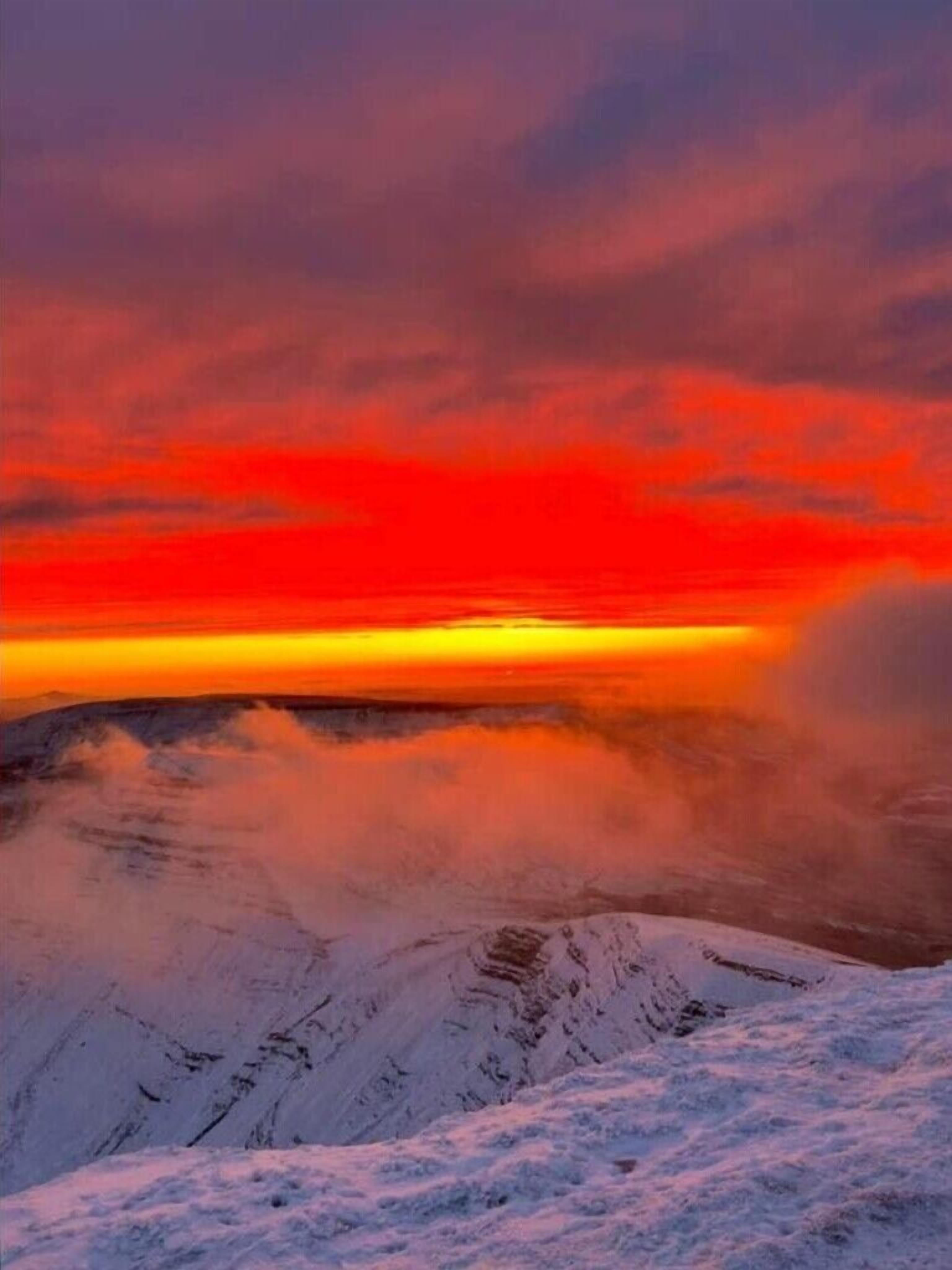 A snowy mountain landscape with a sunset.