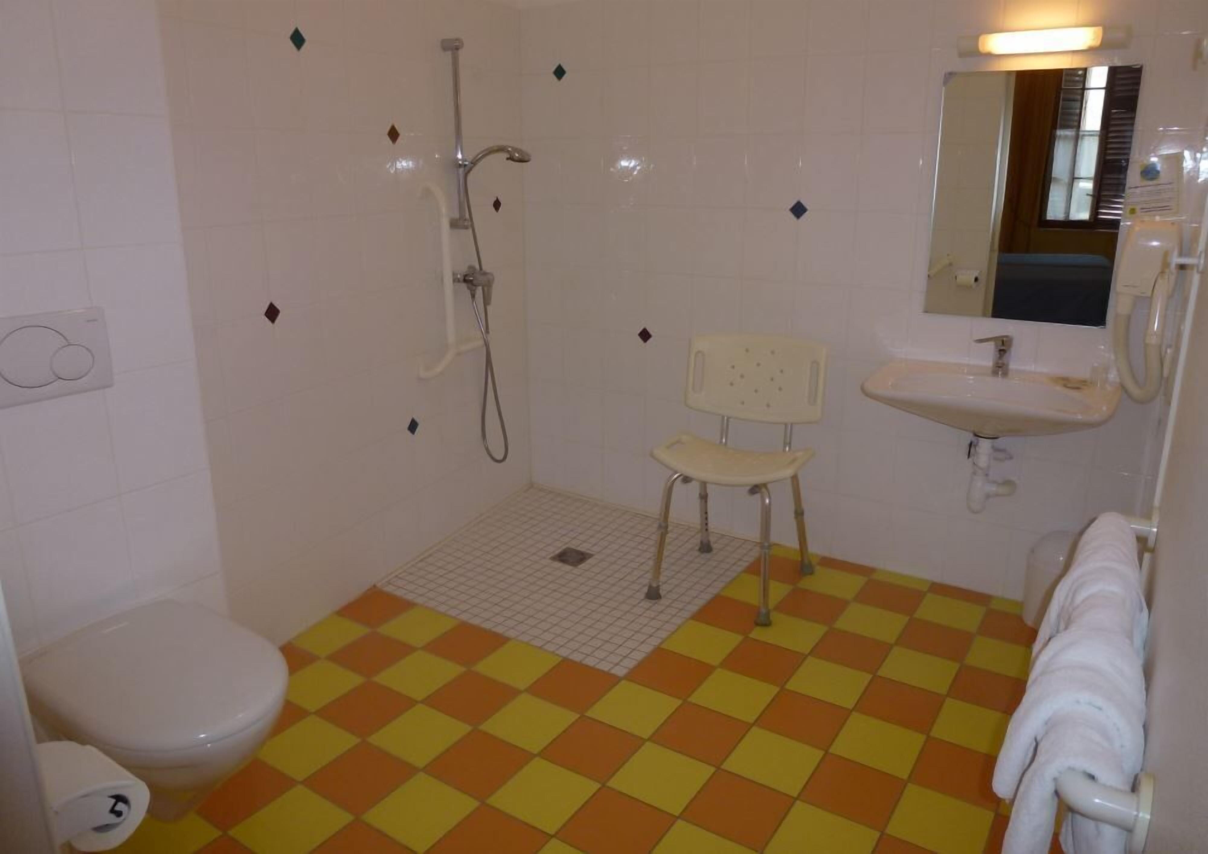 Un baño con ducha, inodoro y lavamanos.