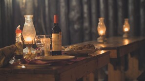 A table set with wine bottles, glasses, and a candle, suggesting a dining or tasting event.