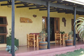 A covered outdoor seating area with wooden benches and planters.