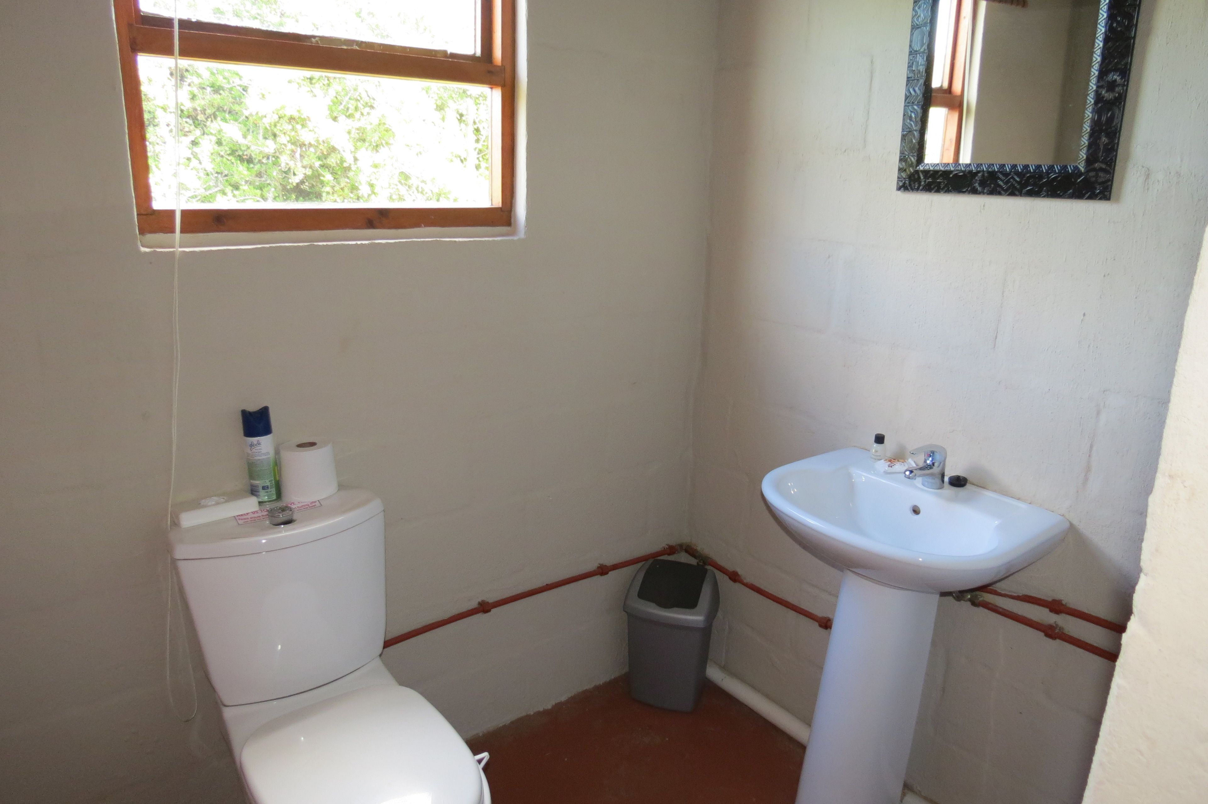 Un baño pequeño con inodoro, lavamanos y ventana.
