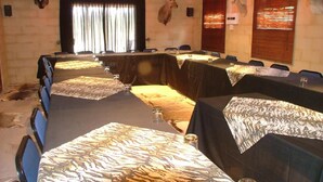 A conference room with tables set for meetings, adorned with animal skulls on the walls, and a rustic decor.