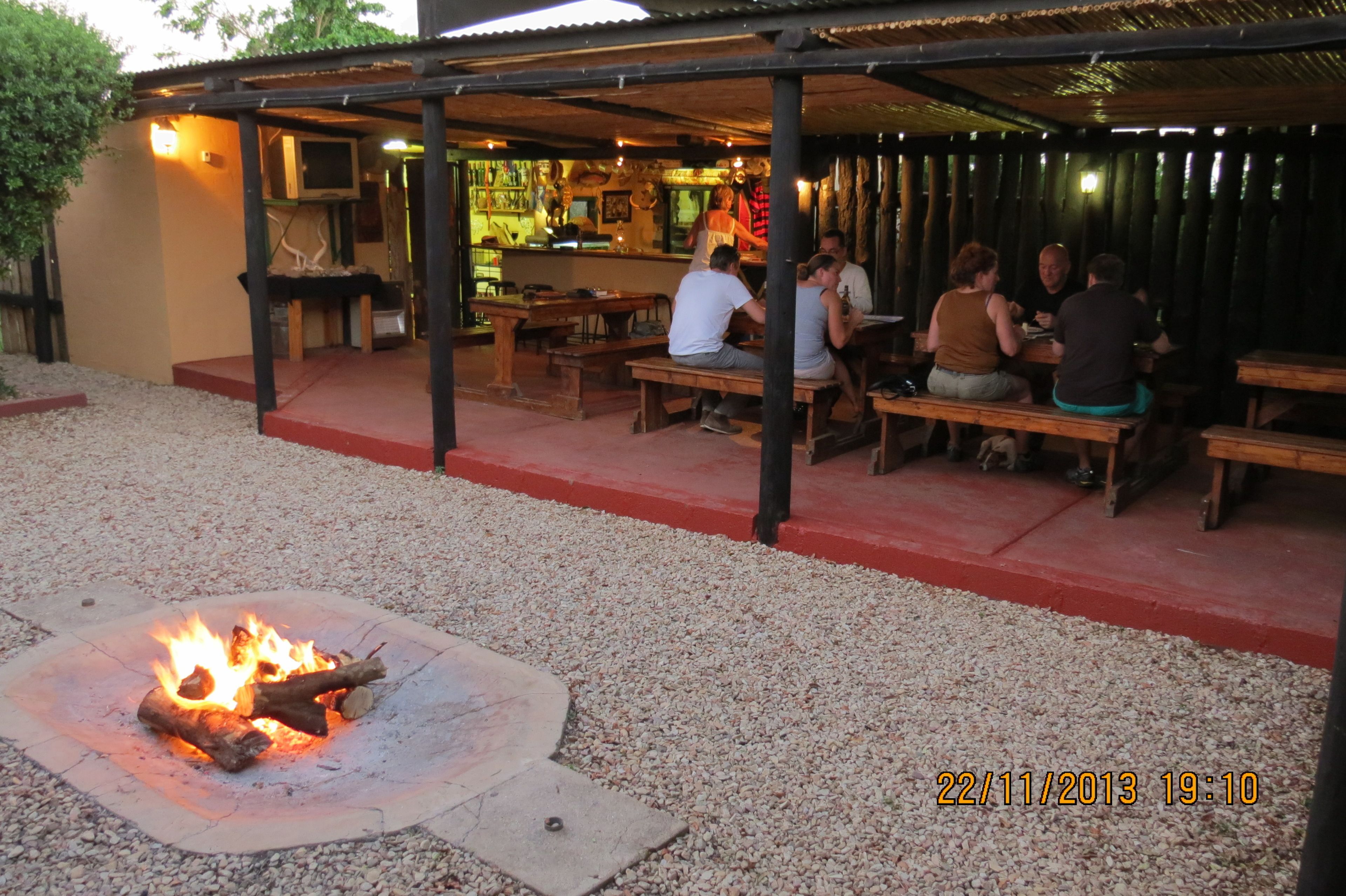 Un espacio al aire libre con bancos de madera y una chimenea.