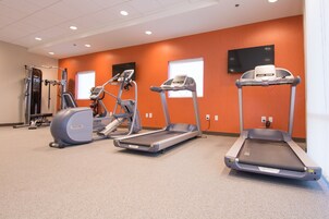 A fitness center with treadmills, elliptical machines, and weight equipment.