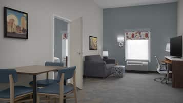 Habitación de hotel con mesa de comedor, sillas, sofá, televisor, lámpara y ventana con cortinas.