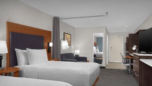 Une chambre d’hôtel avec deux lits, un bureau, une télévision et une salle de bain.