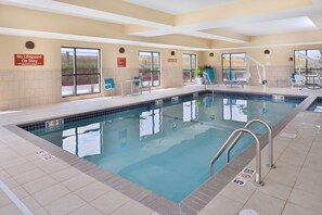 An indoor swimming pool with clear poolside areas, lifeguard signs, and a view of the outdoors. - TownePlace Suites by Marriott Gillette (Gillette)