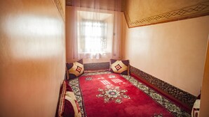 A room with a bed, a window with sheer curtains, and a patterned carpet. - Ecolodge l Ile de Ouarzazate (Tarmigt)
