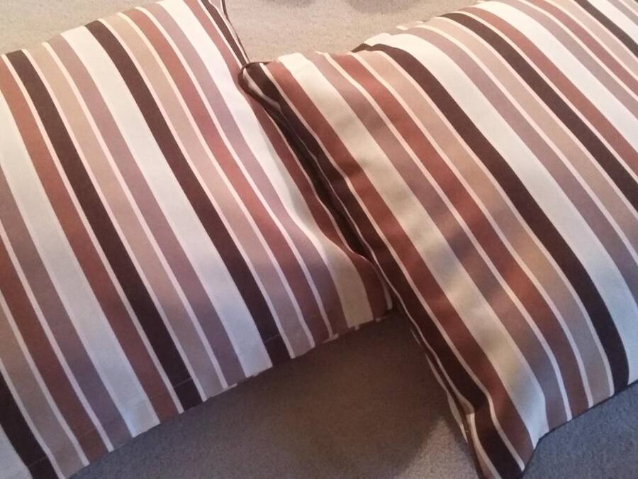 A striped pillow on a couch.