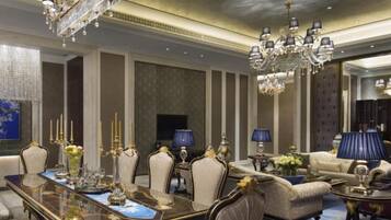 Un comedor lujoso con una mesa larga, sillas elegantes y candelabros ornamentados.