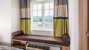 Una habitación con ventana, un banco y un radiador.