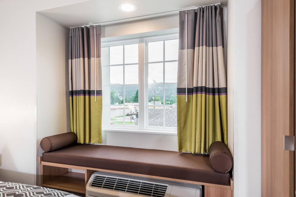 Une pièce avec une fenêtre, un banc et un radiateur.