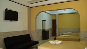 A hotel room with a sofa, two beds, a TV, and a fireplace. - Rustico Santa Teresa (Cóbano)