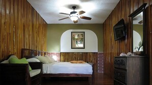 A bedroom with a bed, a wooden dresser, a ceiling fan, and a framed picture on the wall. - Rustico Santa Teresa (Cóbano)