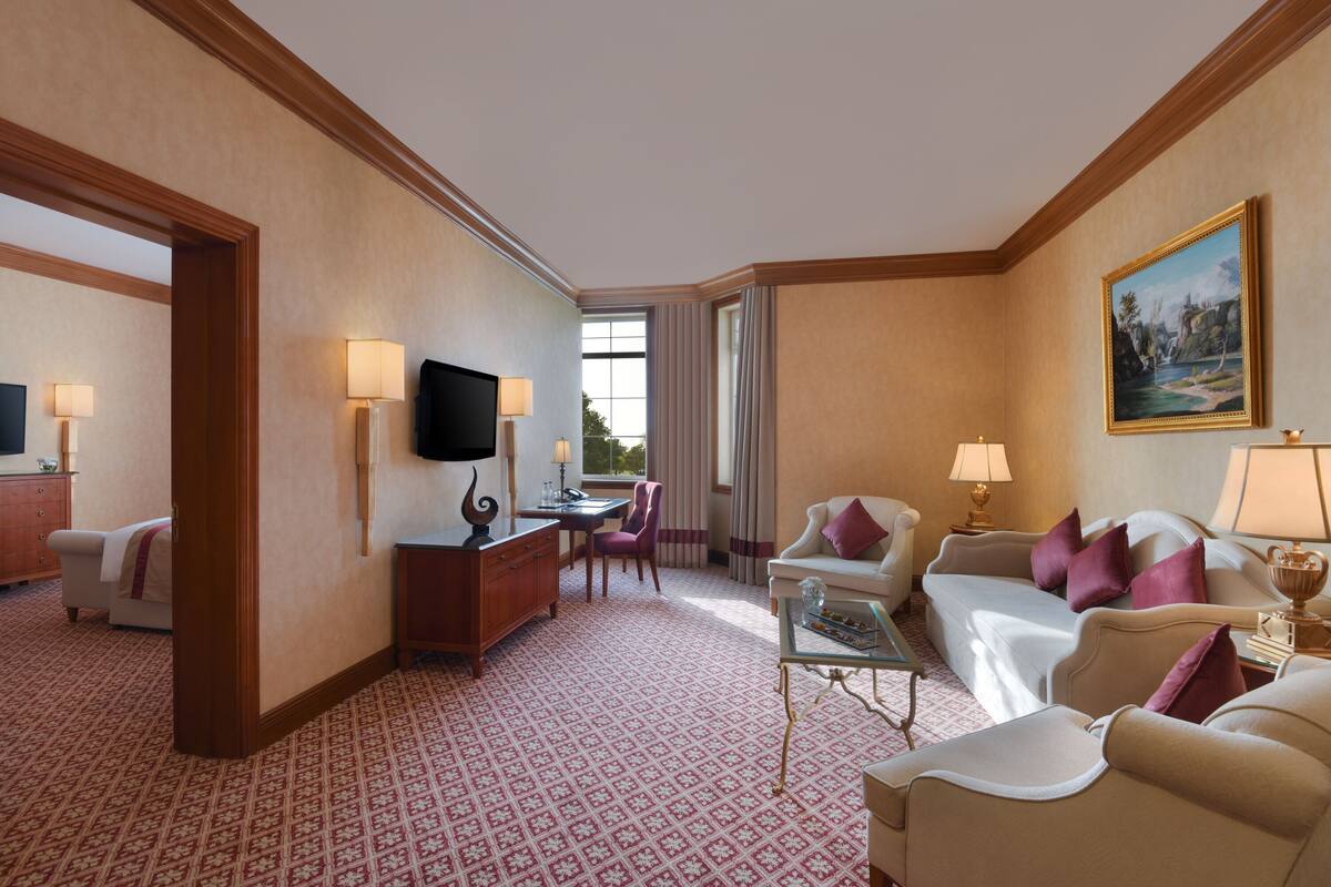 Una habitación de hotel con una cama grande, un escritorio con una silla, un sofá y un televisor.