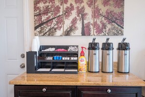 A kitchen counter with a coffee maker, a bottle of coffee creamer, and a set of disposable cups. - Red Roof Inn Wildwood - Cape May/ Rio Grande (Rio Grande)