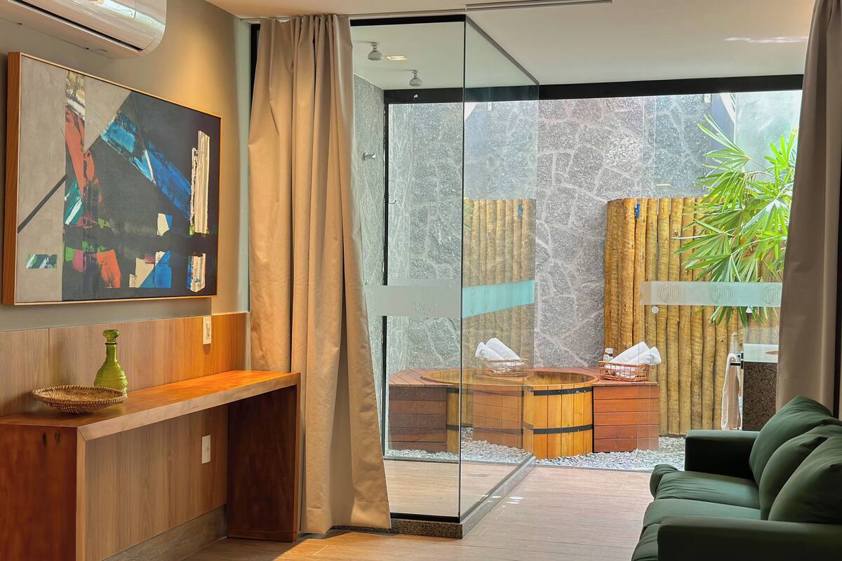 Une salle de bain moderne avec une douche en verre, un meuble-lavabo en bois et un canapé vert.