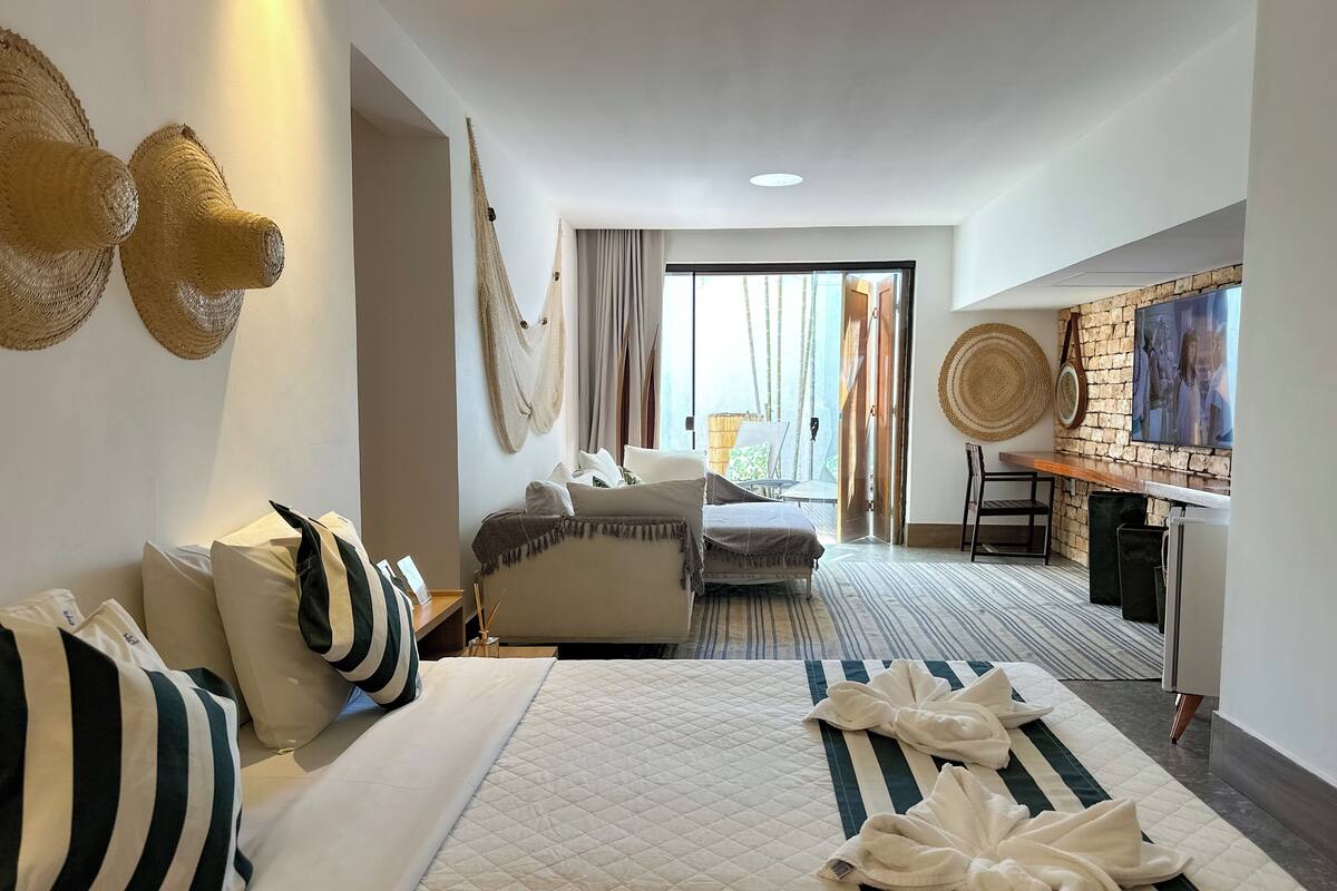 Une chambre d’hôtel avec un lit, un canapé, un bureau et une vue sur l’extérieur.