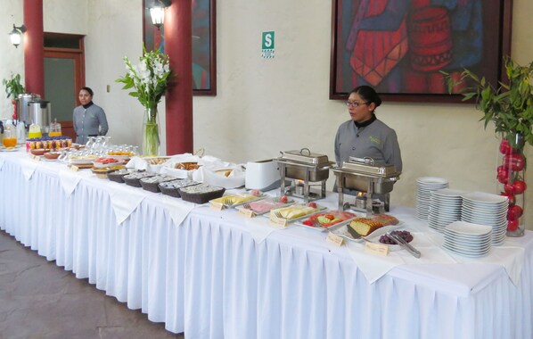 A buffet table with various food items and a staff member standing behind it. - El Refugio Hotel Colca (Chivay)